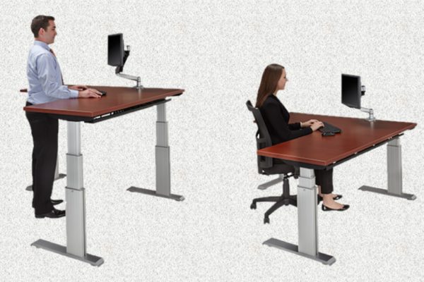 48x72 extended corner 3-stage electric sit-stand desk with programmable height settings, silver powdercoat legs, and medium cherry laminate.