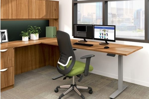 30x60 integrated sit-stand return desk with natural cherry laminate, gray legs, and dual monitor setup.