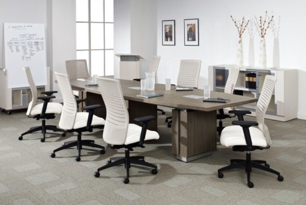 Executive 48x120 boat-shaped conference table with three built-in power modules, raised panel table bases with aluminum accents, and natural walnut laminate finish.