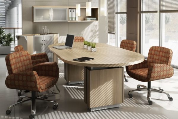 Executive 48x96 racetrack-shaped conference table with two raised panel bases and finished in natural walnut laminate with matching self edge.