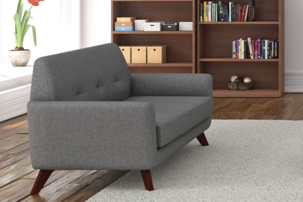 Angled loveseat in gray linen fabric with cherry angled wood legs. Buttoned detail on the seat back.