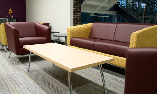 Modern, angular club chair and loveseat in two-tone gold & burgundy fabric/vinyl combination with brushed stainless legs and matching natural maple coffee table.