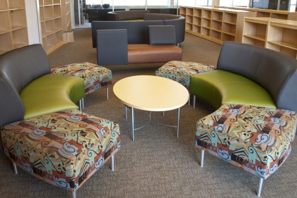 Circular waiting area ensemble with tungsten powdercoat legs, multi-color intermixed vinyls and fabrics, and matching oval-shaped coffee table.