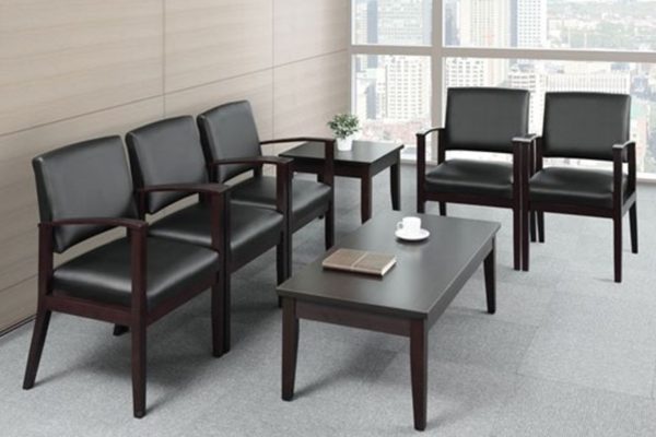 Wood-framed ganging waiting room chairs in black leather with mahogany frames including matching mahogany end table and coffee table.